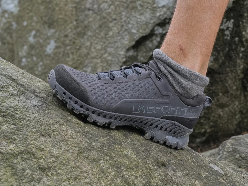 Low-cut hiking shoe flexing on uneven rock, ankle free above the collar