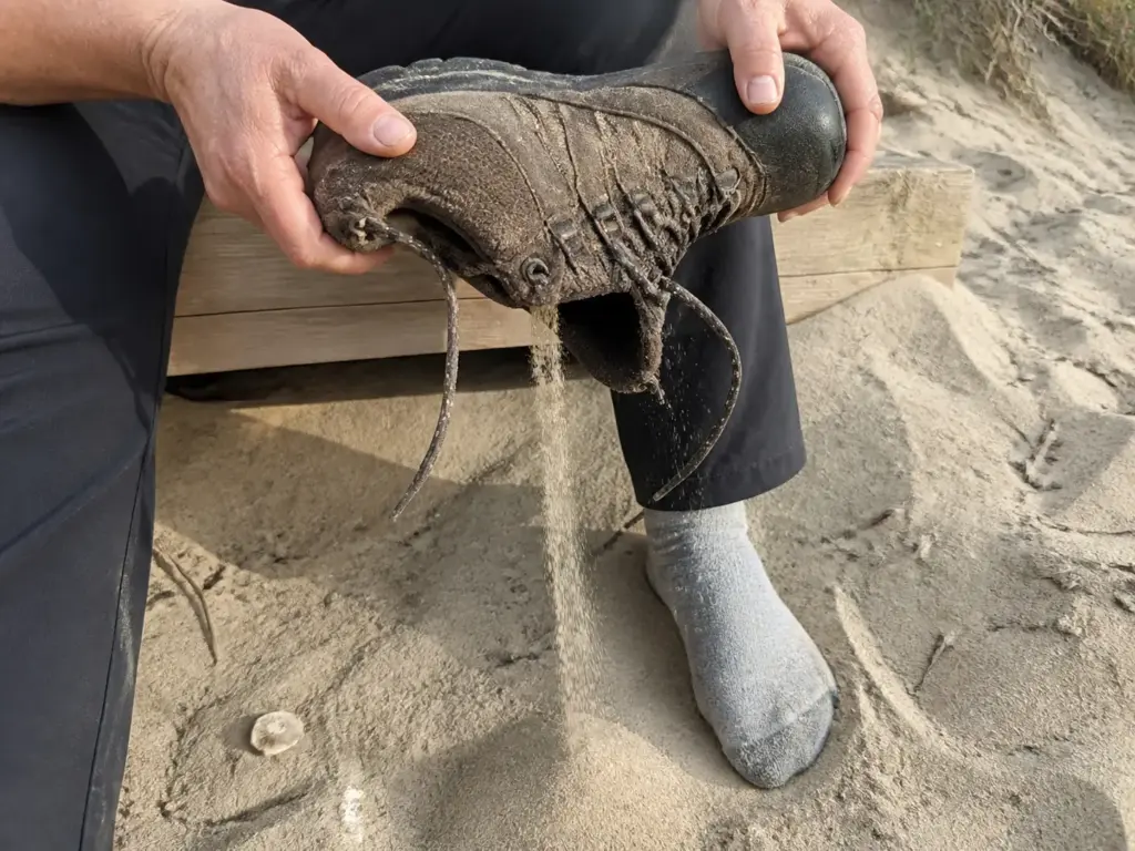 Emptying sand from a low-cut hiking shoe on the dunes at Hither Hills, Montauk, on a Long Island hike.