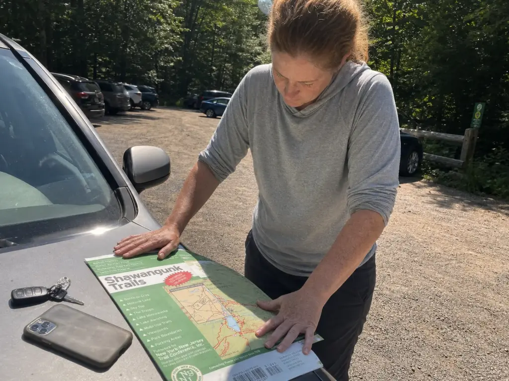 Hiker spreading a Shawangunk trails map on a car hood at the Jenny Lane parking lot