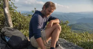Best Thru-Hiking Shoes That Actually Reach 700 Miles Thru-hiker checking worn Altra Lone Peak trail runners on an Appalachian Trail ridgeline