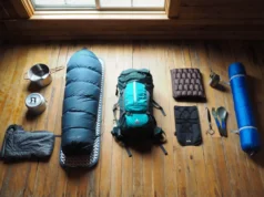 Backpacking Essentials: A Beginner to Expert Gear Guide A flat lay of backpacking gear showing a progression from beginner items on the left to expert ultralight equipment on the right.