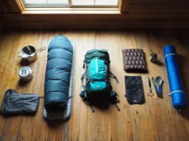 A flat lay of backpacking gear showing a progression from beginner items on the left to expert ultralight equipment on the right.