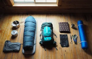 Backpacking Essentials: A Beginner to Expert Gear Guide A flat lay of backpacking gear showing a progression from beginner items on the left to expert ultralight equipment on the right.