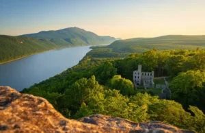 Master Cold Spring, NY Hiking: From Bull Hill to Ruins Expansive view from Bull Hill in Cold Spring, NY, showing the Hudson River and the Cornish Estate ruins at golden hour.