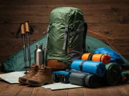 Essential backpacking gear including a backpack, sleeping bag, tent, trekking poles, and map.