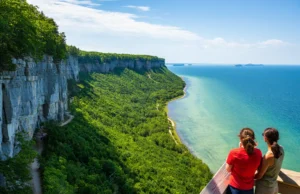 All 10 Peninsula State Park Trails Ranked (Maps & Tips) A wide, panoramic view from an overlook at Peninsula State Park, showing the dramatic cliffs, Green Bay, and multiple hiking trails through the forest.