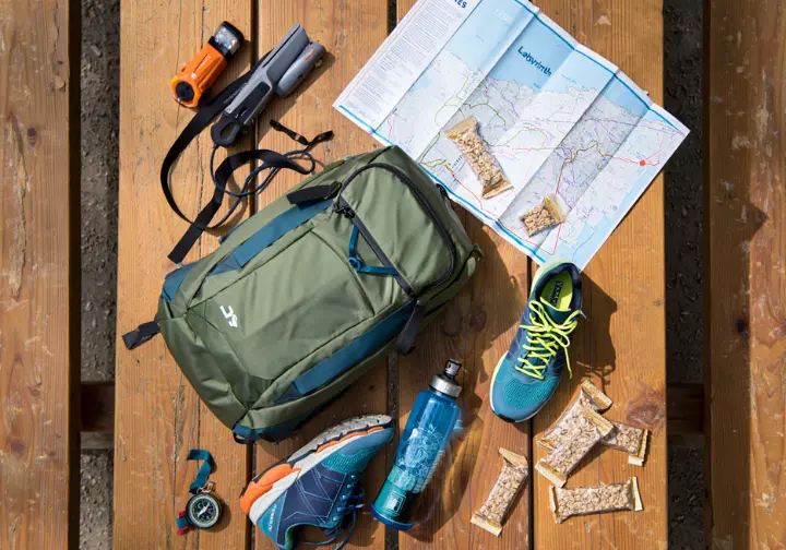 Essential hiking gear for the Mohonk Lemon Squeeze, including a small backpack, headlamp, and map, laid out in a tactical briefing style.