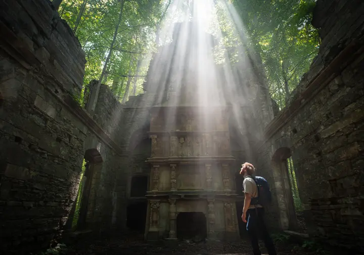 A hiker exploring the historic stone ruins of the Cornish Estate near Cold Spring, NY.