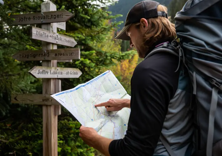A hiker studies a trail map at a junction, choosing a Plan B hike as an alternative after being unable to get a Joffre Lake day pass.