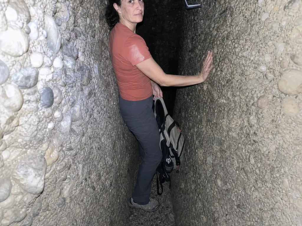 Hiker turned sideways in the tight Lemon Squeeze crevice at Mohonk deciding whether to continue