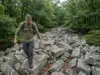 Hiking in Central PA Where the Rules Change Midtrail Hiker crossing a blocky sandstone rock field while hiking in Central PA's Ridge-and-Valley ridgeline