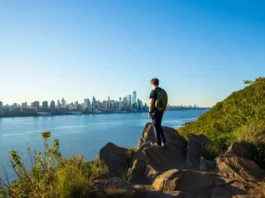 Hiker enjoying panoramic New York City skyline views from a top hiking trail viewpoint in North Jersey.