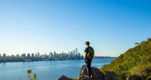 Best Hikes in North Jersey? NYC Skyline Views! Hiker enjoying panoramic New York City skyline views from a top hiking trail viewpoint in North Jersey.