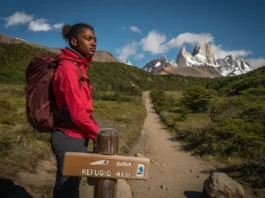 Hiker at a trail junction in Patagonia contemplating the choice between a guided tour route versus hiking independently.
