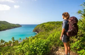 Secret St Thomas Hiking Trails: Beyond Beaches! Hiker enjoying a scenic viewpoint on a secret St Thomas hiking trail, looking out over the coastline beyond the beaches.