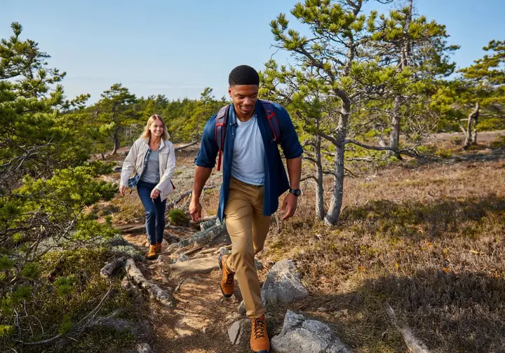 Hikers navigating the rocky Verkeerder Kill Falls trail, showcasing hiking trails at Sam's Point, Minnewaska State Park Preserve.