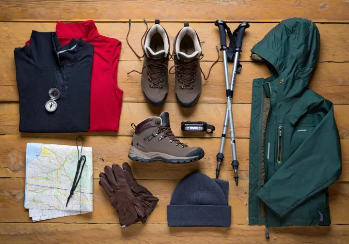 Essential gear for gearing up for May hikes in Switzerland: waterproof boots, layers, map, compass, poles, headlamp, hat, gloves.