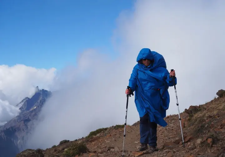 Addressing common challenges: Hiker battling strong wind on an exposed trail in Patagonia, highlighting weather risks.