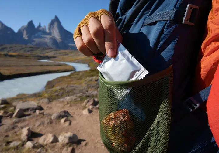 Hiking responsibly in Patagonia: Hiker packing out trash according to Leave No Trace principles on a scenic trail.