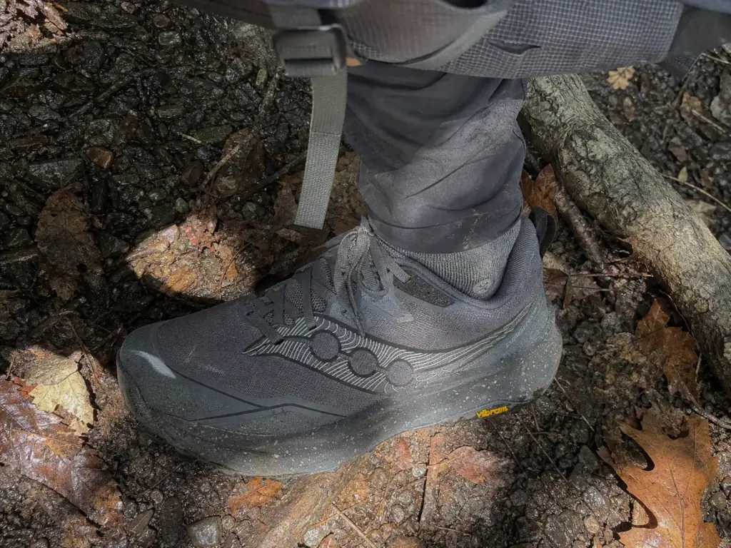 Worn trail runner midsole creasing under a loaded backpacking pack on the Appalachian Trail