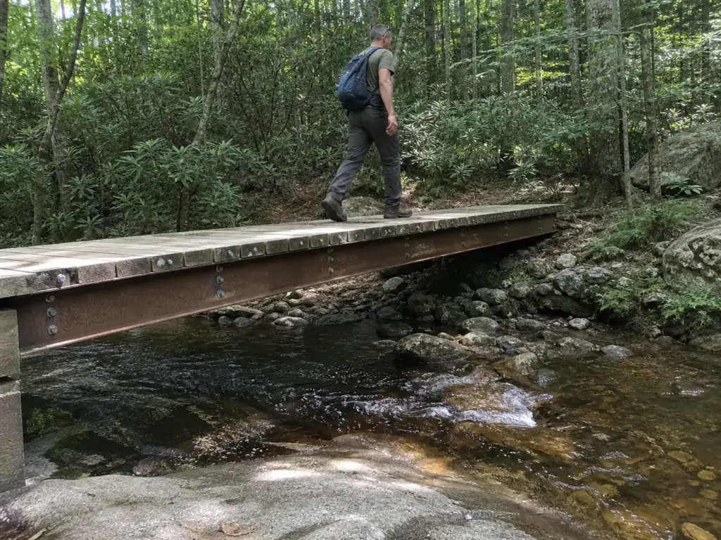 Wooden and steel footbridge over a small stream on a Fahnestock State Park hiking trail