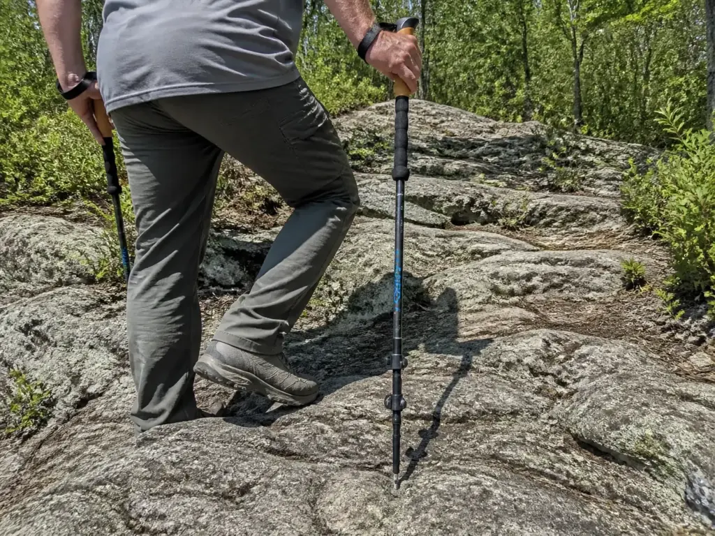 Hiker using trekking poles on a rocky ridge section of the Sterling Forest fire tower trail