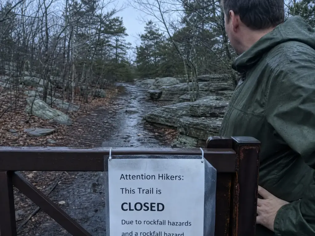 Seasonal closure sign at a Sam's Point trail gate where the ice caves shut in winter and spring
