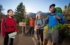 The 10 Essentials Explained: A Day Hiking Checklist Hikers preparing at a mountain trailhead, showcasing readiness for a day hike with essential gear.