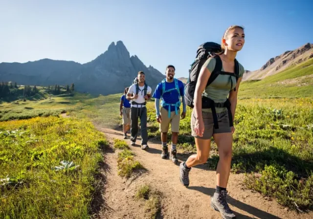 Diverse hikers demonstrating effective pacing on a scenic mountain trail, embodying sustained endurance and energy management for longer hikes.