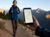 The Route Planner’s Blueprint: From Idea to GPX File A hiker viewing a digital map with a planned route on a smartphone in a mountain landscape, representing the process of planning a hiking route using digital mapping tools.