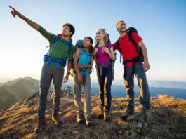 Four diverse thru-hikers stand on a mountain summit at golden hour, overlooking vast peaks, embodying the mind, body, and budget preparation for a long-distance trail.