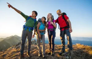 Thru-Hiking: A Guide to Mind, Body, & Budget Prep Four diverse thru-hikers stand on a mountain summit at golden hour, overlooking vast peaks, embodying the mind, body, and budget preparation for a long-distance trail.
