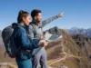 The UL Blueprint: A Guide to Skills, Not Just Gear Two diverse hikers, one male and one female, at a mountain overlook, demonstrating ultralight backpacking skills with lightweight gear in a clear, sunny landscape.