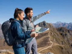 The UL Blueprint: A Guide to Skills, Not Just Gear Two diverse hikers, one male and one female, at a mountain overlook, demonstrating ultralight backpacking skills with lightweight gear in a clear, sunny landscape.
