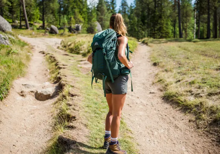 A hiker contemplating a trail fork, symbolizing the dilemmas and ethical decision-making in Leave No Trace practices.