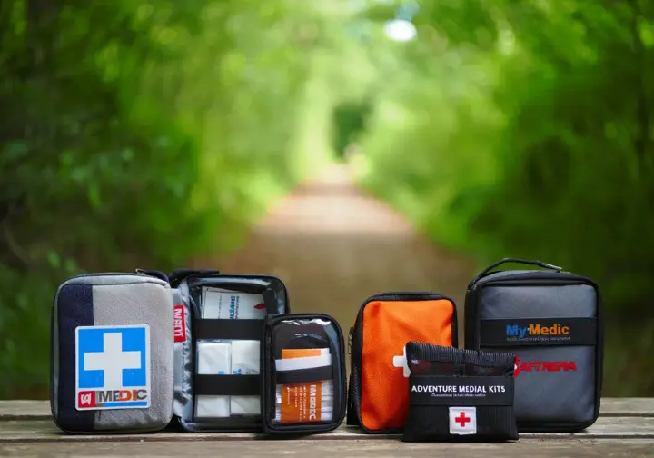 Several pre-made hiker's first-aid kits from different brands laid out, showing options for building upon a quality base kit.