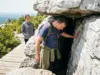 7 Things to Know Before Sam’s Point Ice Cave Hikers entering a narrow rock crevice at the Sam's Point Ice Cave in the Shawangunk Mountains, New York