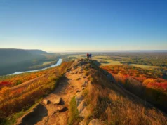 Explore CT: Hikes From Beginner to Expert A stunning autumn view from a hiking trail overlook in Connecticut, with hikers looking out over colorful, rolling hills.