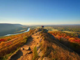 A stunning autumn view from a hiking trail overlook in Connecticut, with hikers looking out over colorful, rolling hills.