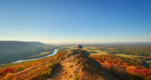 Explore CT: Hikes From Beginner to Expert A stunning autumn view from a hiking trail overlook in Connecticut, with hikers looking out over colorful, rolling hills.