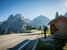 The Definitive Guide: Hiking Europe’s Parks Car-Free A prepared hiker with a backpack waits at a bus stop on a scenic mountain road in the European Alps, as a local bus arrives to begin a car-free day of hiking.