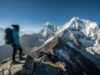 The Science of Altitude Sickness: A Hiker’s Field Guide A female hiker stands on a high mountain ridge, looking out over a vast range of peaks, illustrating the concept of a hiker's field guide to the science of altitude sickness.