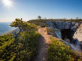 A panoramic view of the Sam's Point Ice Cave trail leading to a dramatic overlook with the Shawangunk Mountains and Hudson Valley in the background.