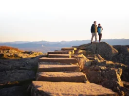 A couple enjoying the panoramic view from Pinwheel's Vista after completing the Stairway to Heaven hike in New Jersey.