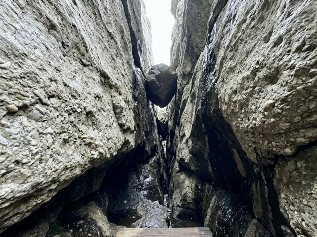 Cold damp quartz conglomerate walls deep inside the Sam's Point Ice Cave with daylight far overhead