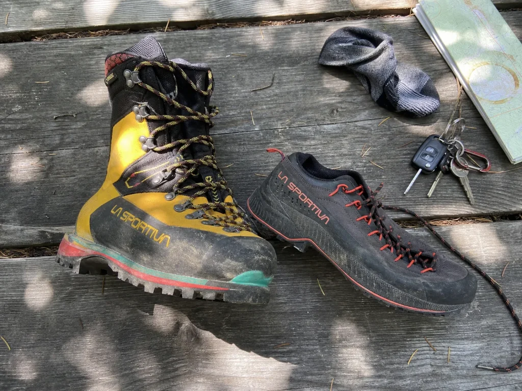A stiff hiking boot and a flexible low-cut hiking shoe side by side showing different construction
