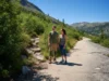 The Hiker’s Guide: Pants vs. Leggings for All Conditions A man in hiking pants and a woman in leggings stand at a trail fork, deciding whether to take the rugged path or the smooth path.