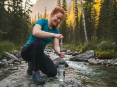 Sawyer Squeeze Field Guide: Clean, Sanitize & Store Fast A beautiful female hiker with red hair confidently cleaning her Sawyer Squeeze water filter by a mountain stream.