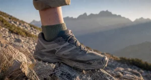 Do You Need a Rock Plate for Hiking? Not Always Low-cut hiking shoe stepping onto sharp granite on a rocky trail at first light, sole flexing over a pointed rock