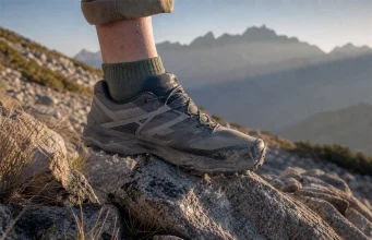 Do You Need a Rock Plate for Hiking? Not Always Low-cut hiking shoe stepping onto sharp granite on a rocky trail at first light, sole flexing over a pointed rock